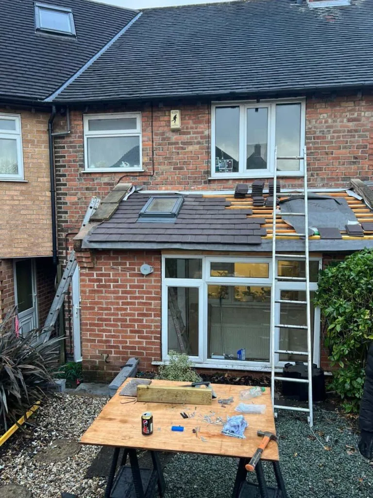 This is a photo of a roof extension that is having new roof tiles installed. This is a photo taken from the roof ridge looking down a tiled pitched roof on to a flat roof. Works carried out by MCM Roofing Repairs Romsey